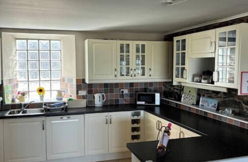 Bangor Cottage | Splash Cottage Beach house with sea touching back garden